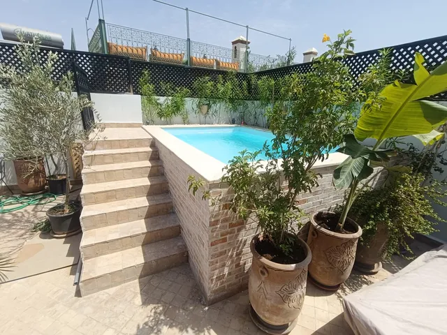 Piscine hors-sol en polyester surélevée avec habillage en pierre, réalisation à Tanger
